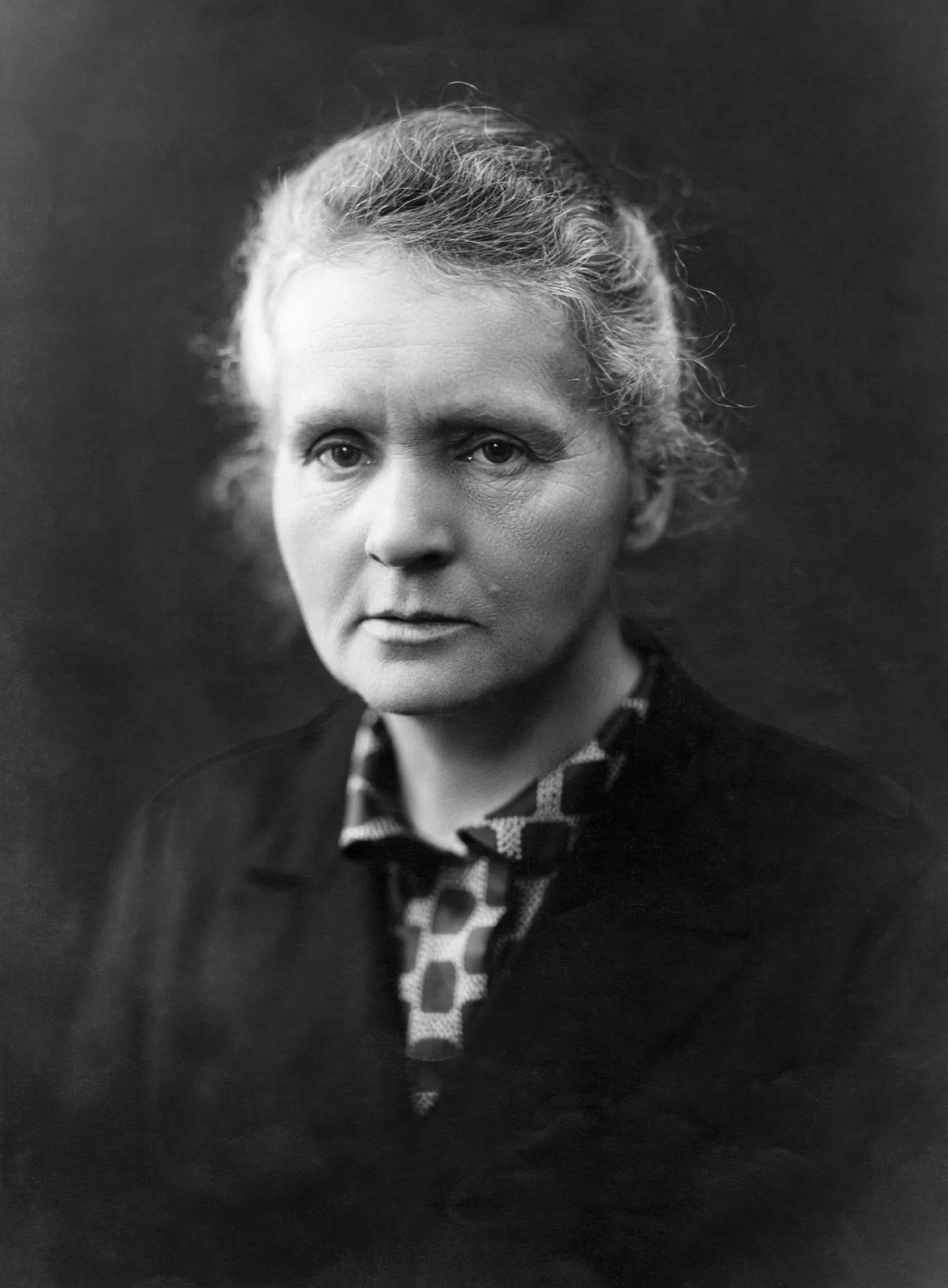 Portrait of Marie Curie in dark dress, facing the camera