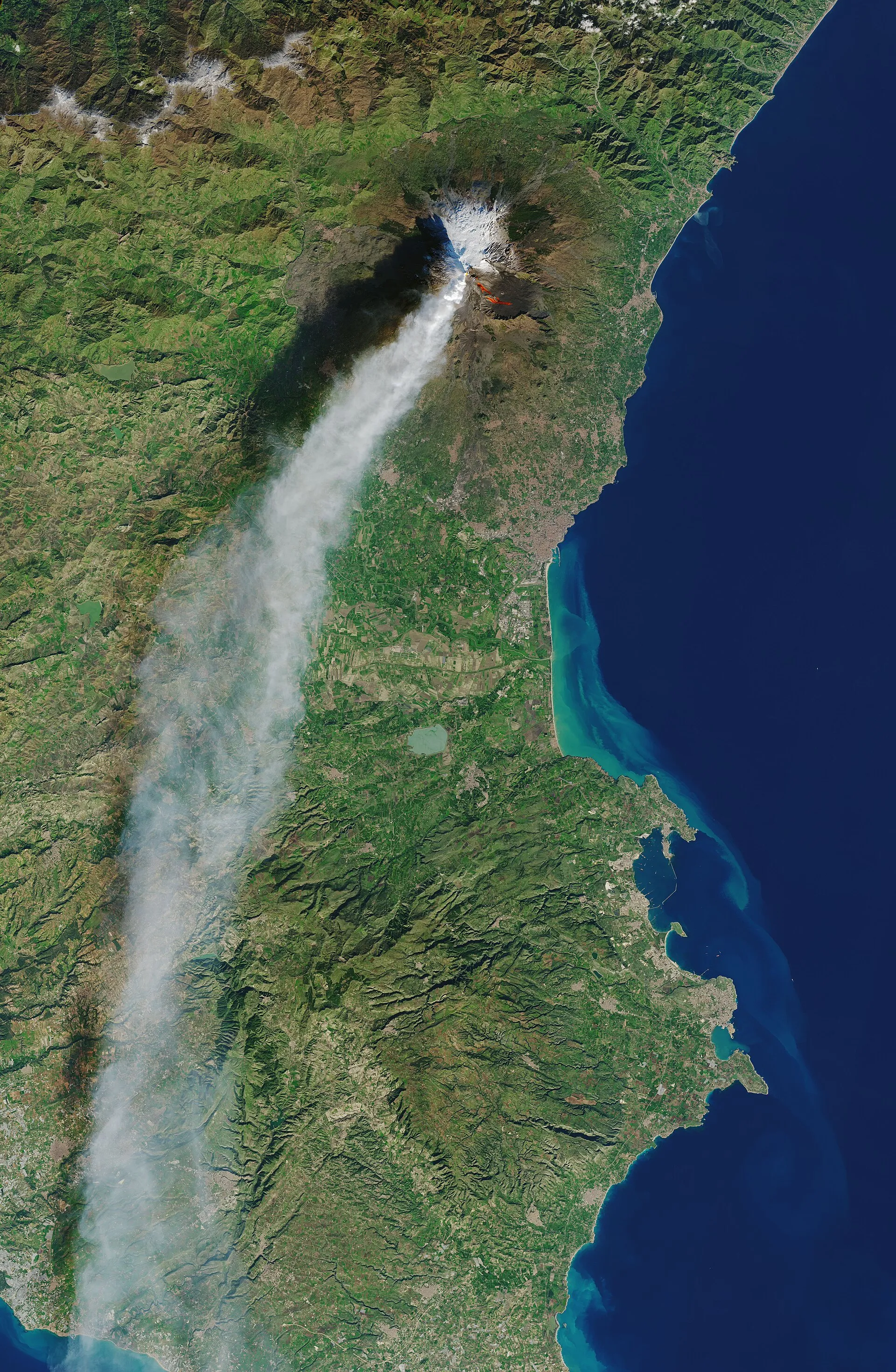 Satellite view of a long ash plume streaming from Mount Etna across Sicily