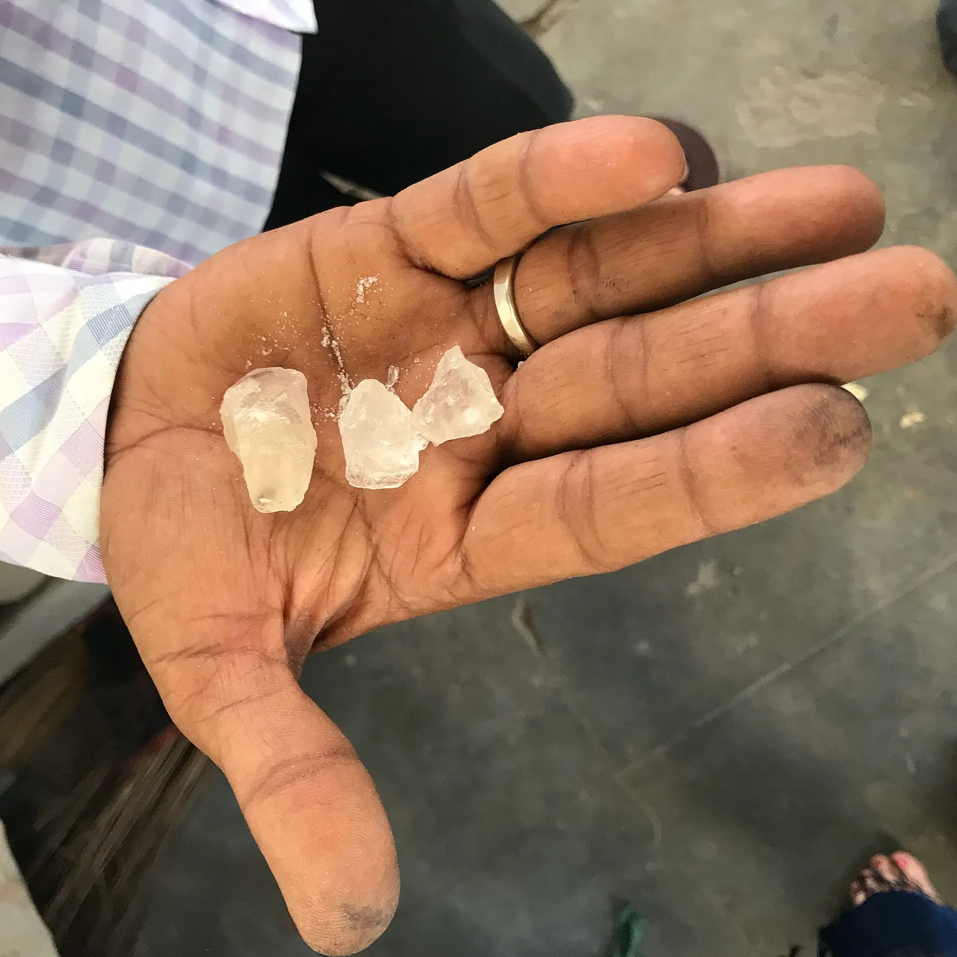 Translucent alum crystals resting in an open palm