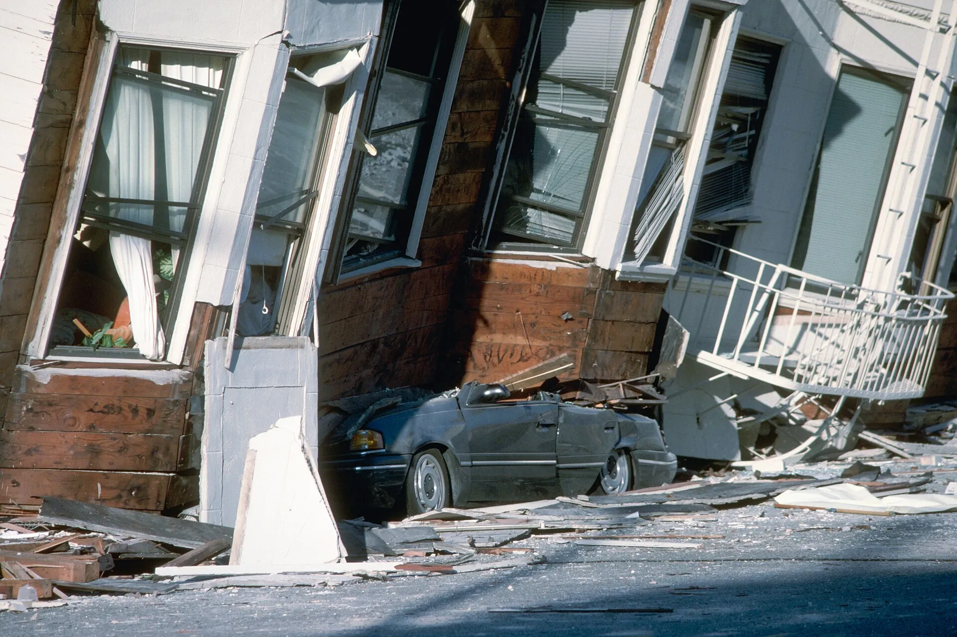 Collapsed building resting on a crushed car after the 1989 Loma Prieta earthquake