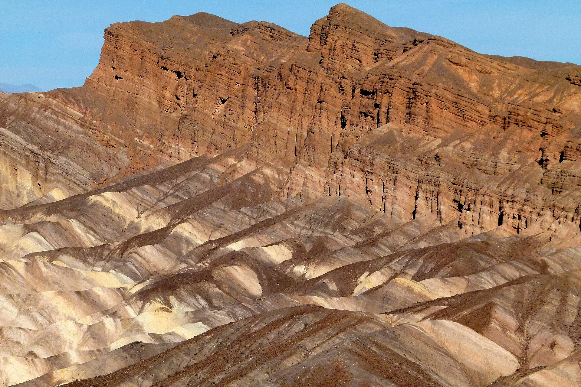 Folded and layered rock strata exposed across desert badlands