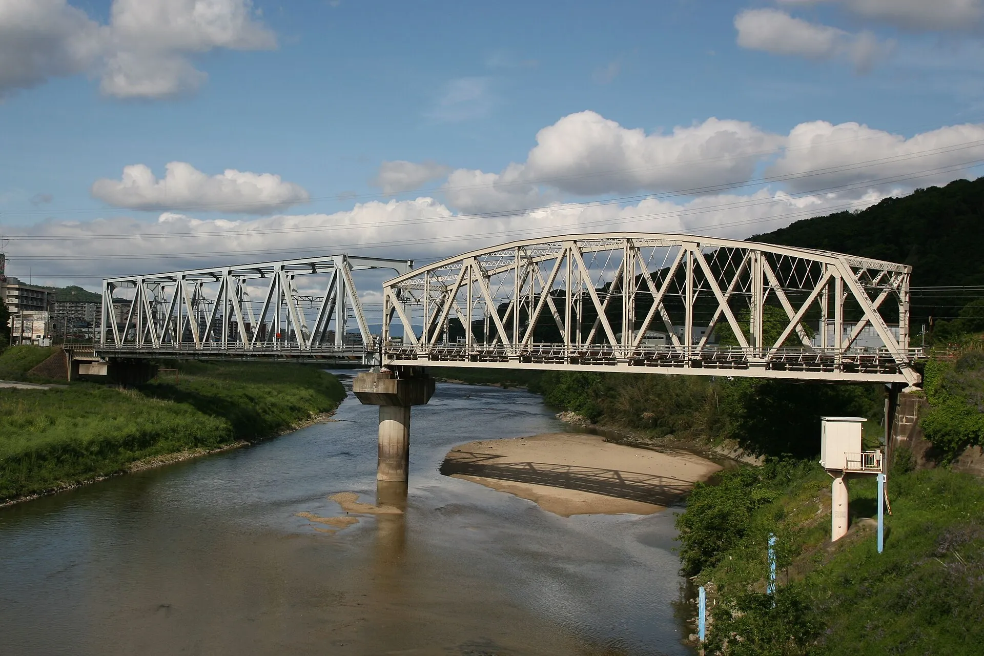 White Warren truss bridge with zigzag diagonals spanning a river