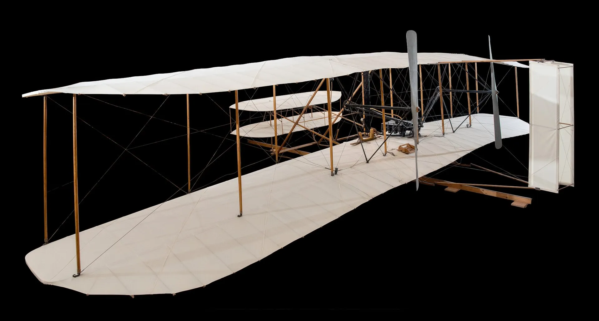 The Wright brothers' 1903 Flyer with its white wings and wooden frame