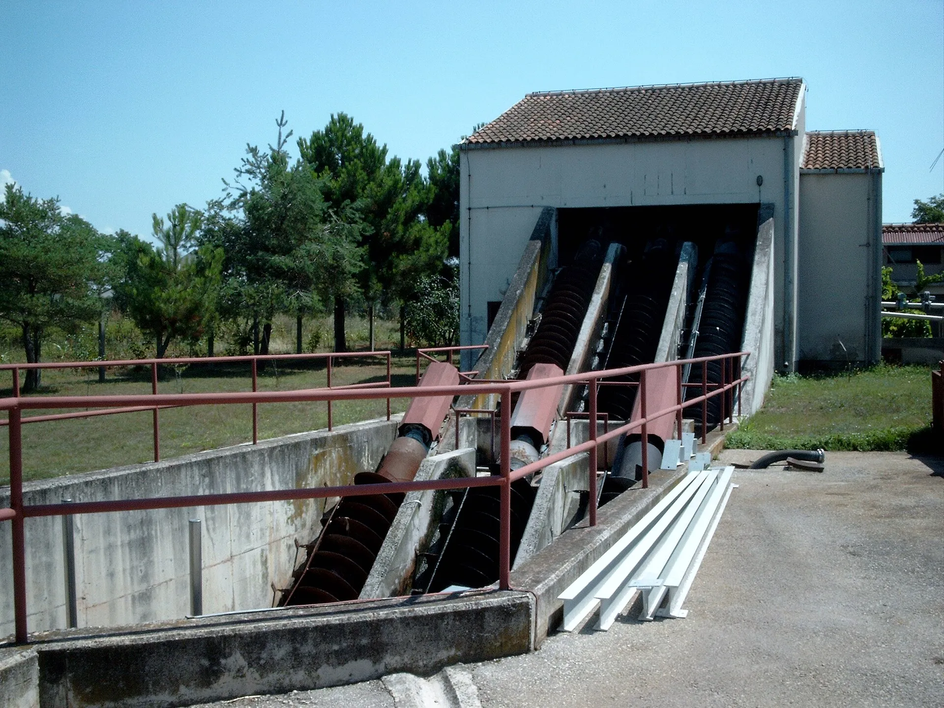 Modern Archimedes screw pumps lifting water at a small pumping station