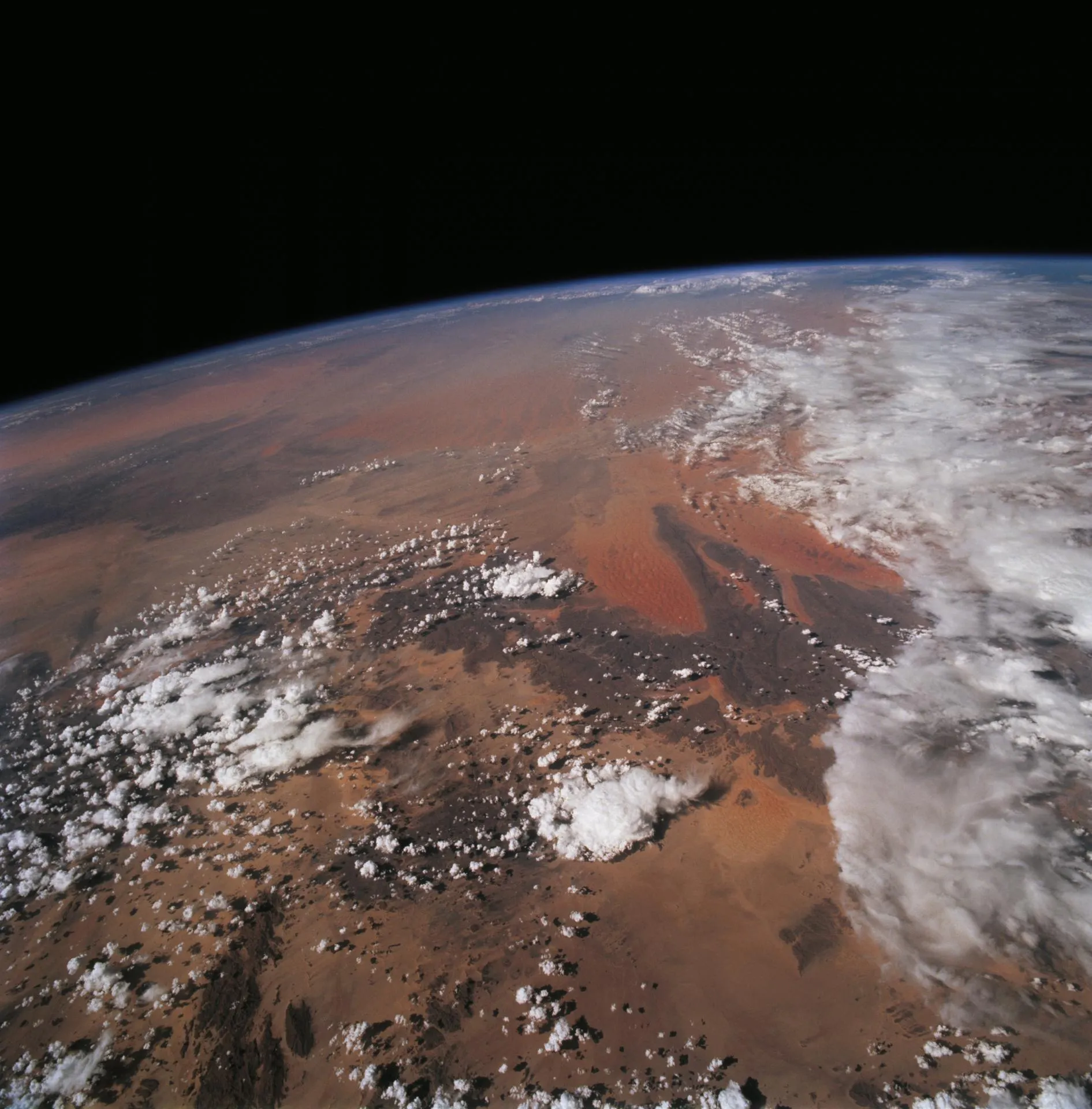 The Sahara under scattered cloud, seen from orbit with Earth's curvature