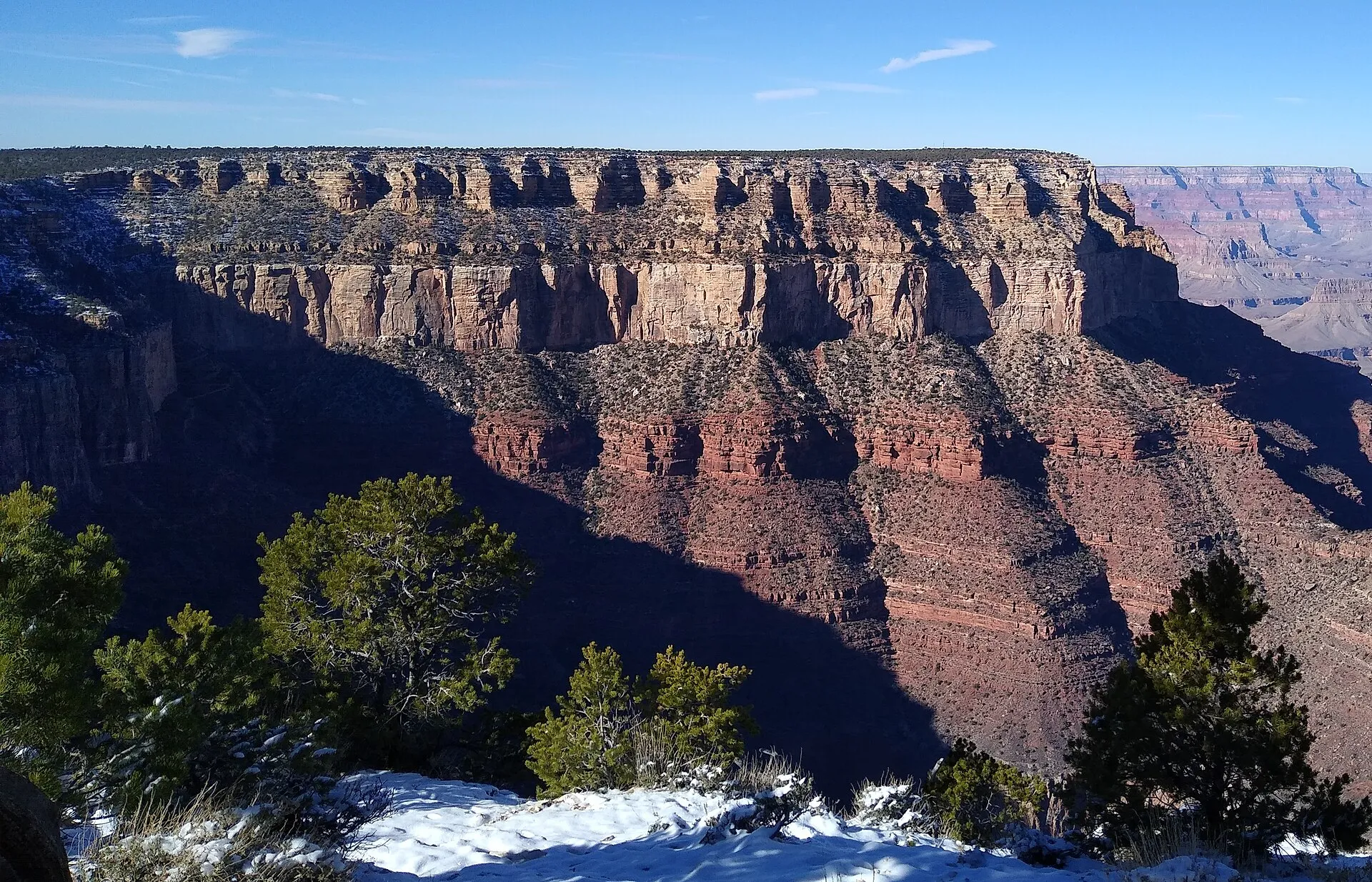 Layered sedimentary rock walls of the Grand Canyon at dusk