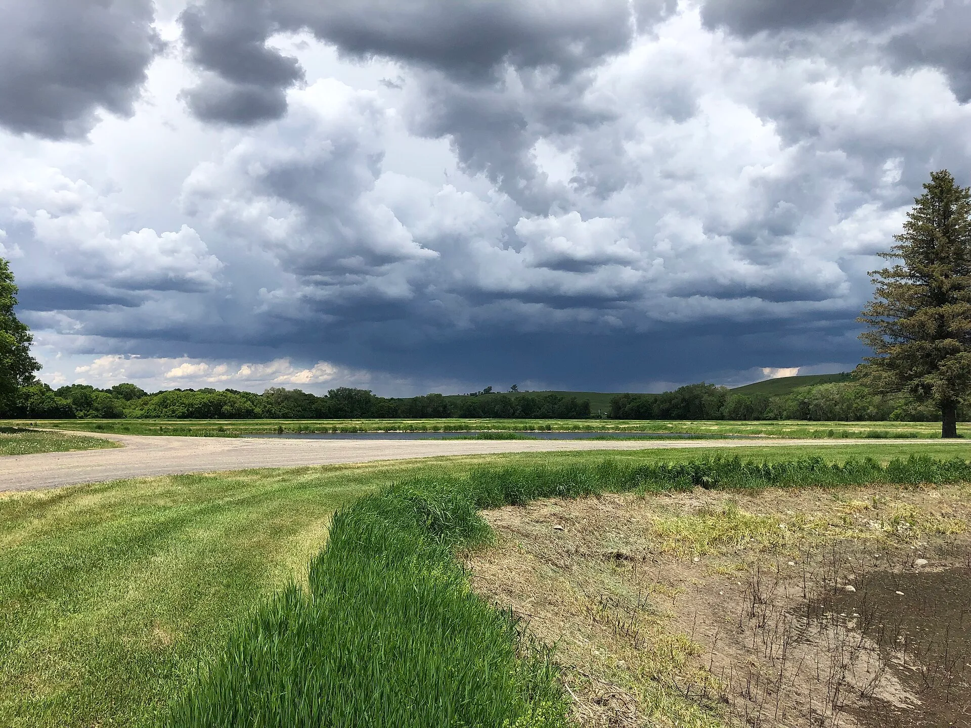 Wall of dark storm clouds advancing over open farmland