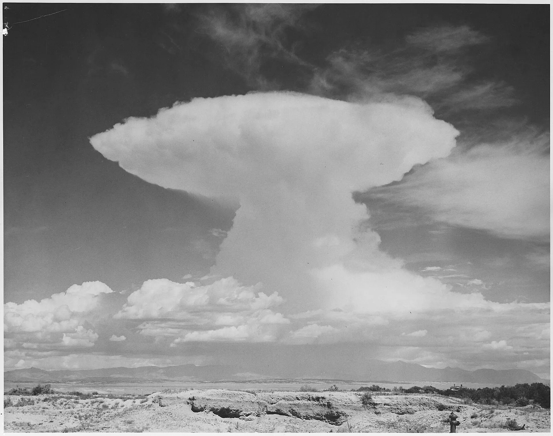 Anvil-topped cumulonimbus cloud towering over a flat landscape