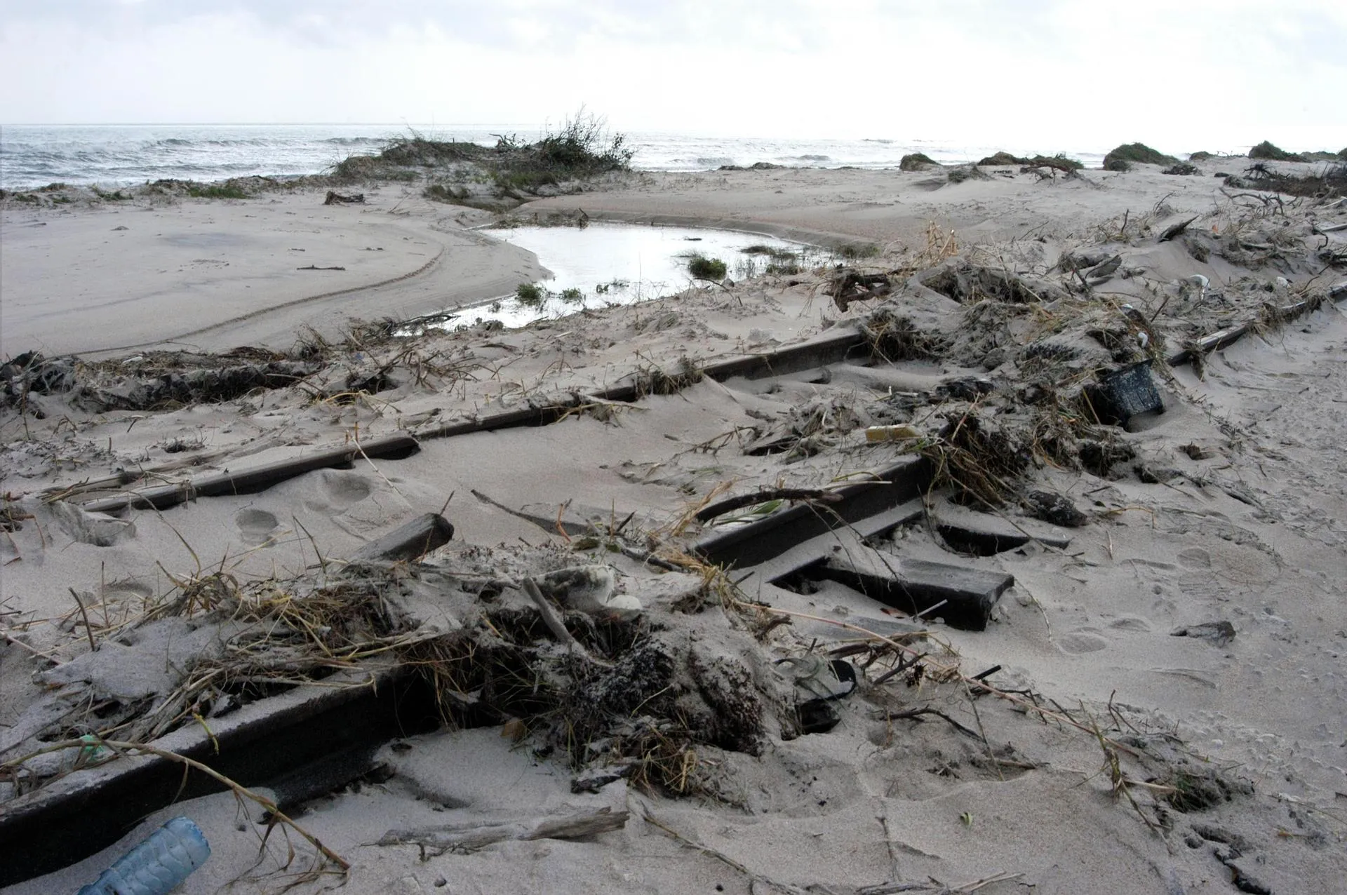 Dune line breached and buried by storm surge along a coastline