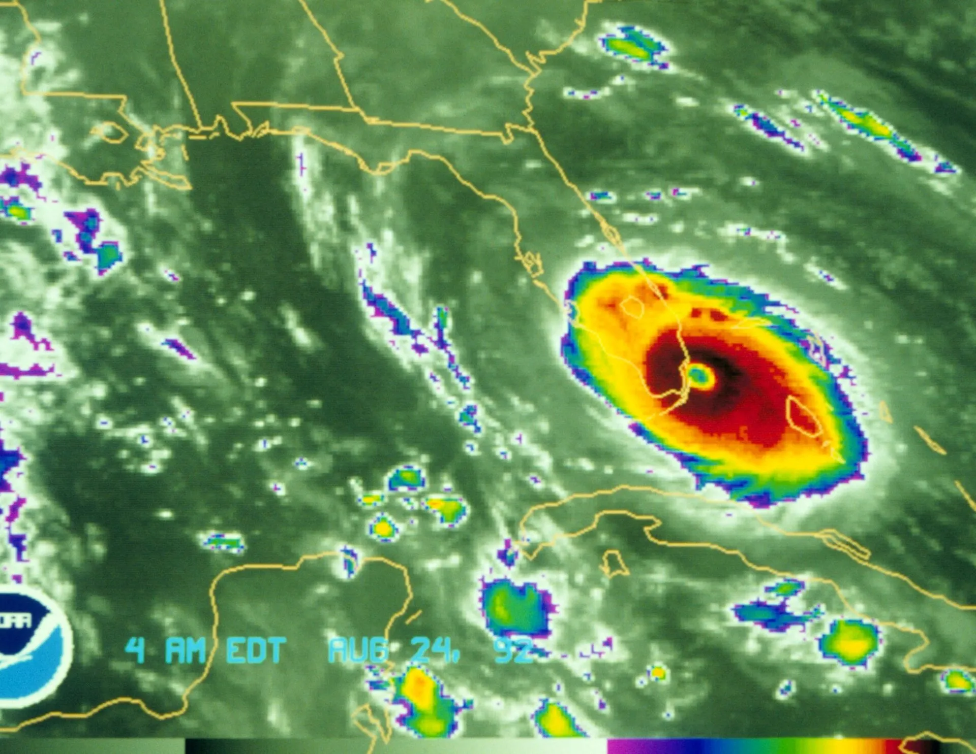 Weather satellite view of a hurricane's colored bands and eye approaching a coastline